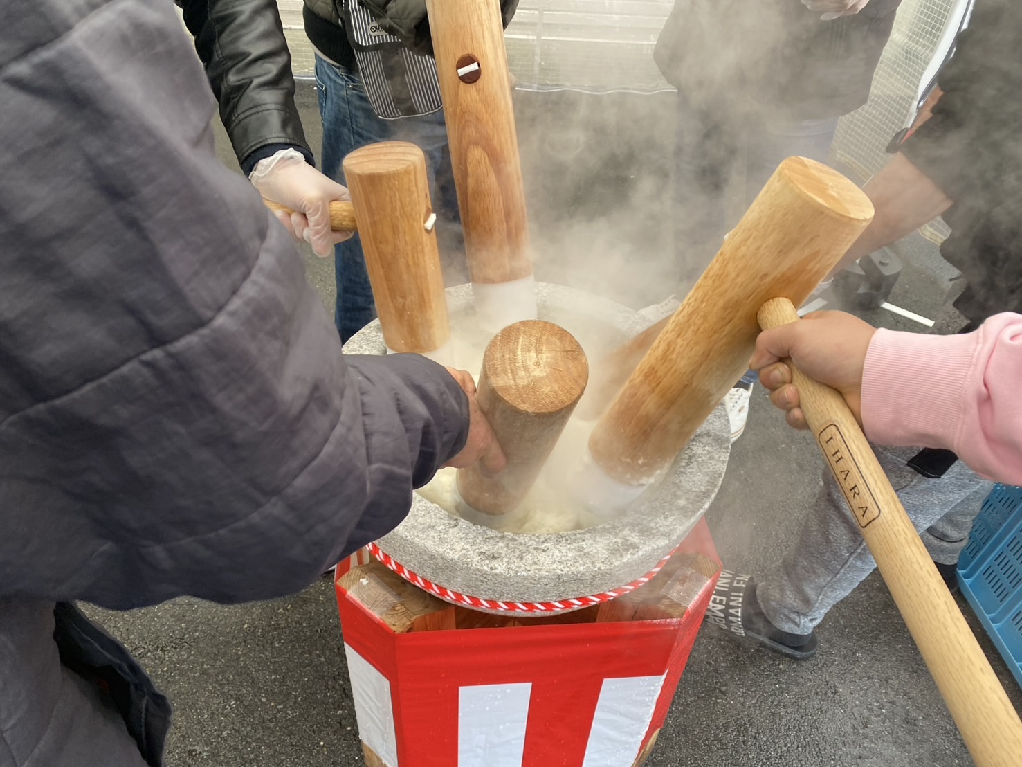臼を囲んで迫力ある餅つきシーン