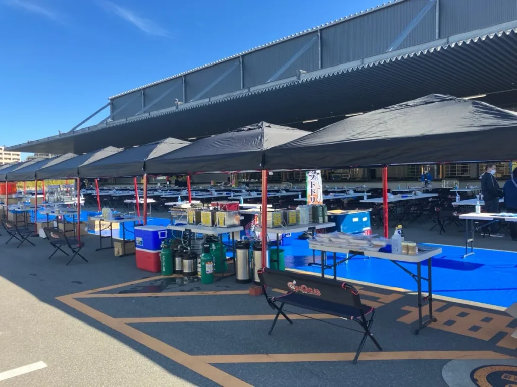 屋根の下にタープテントとテーブルを並べた大人数のBBQ会場（イメージ画像）