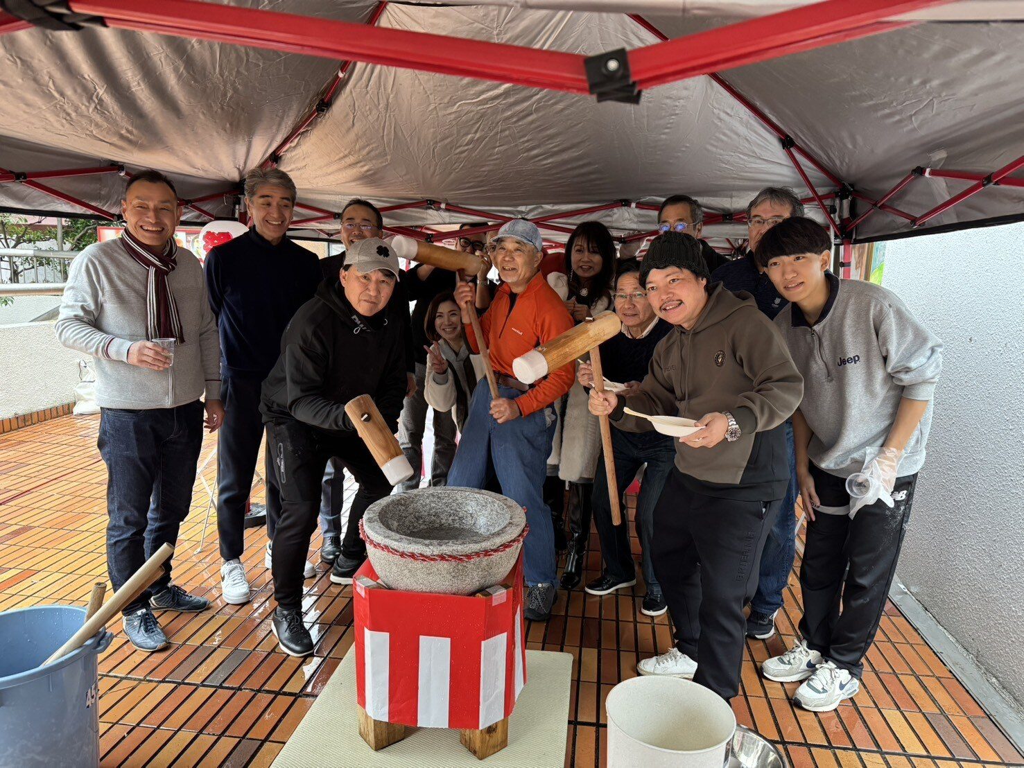 スタッフと参加者が盛り上がる餅つき