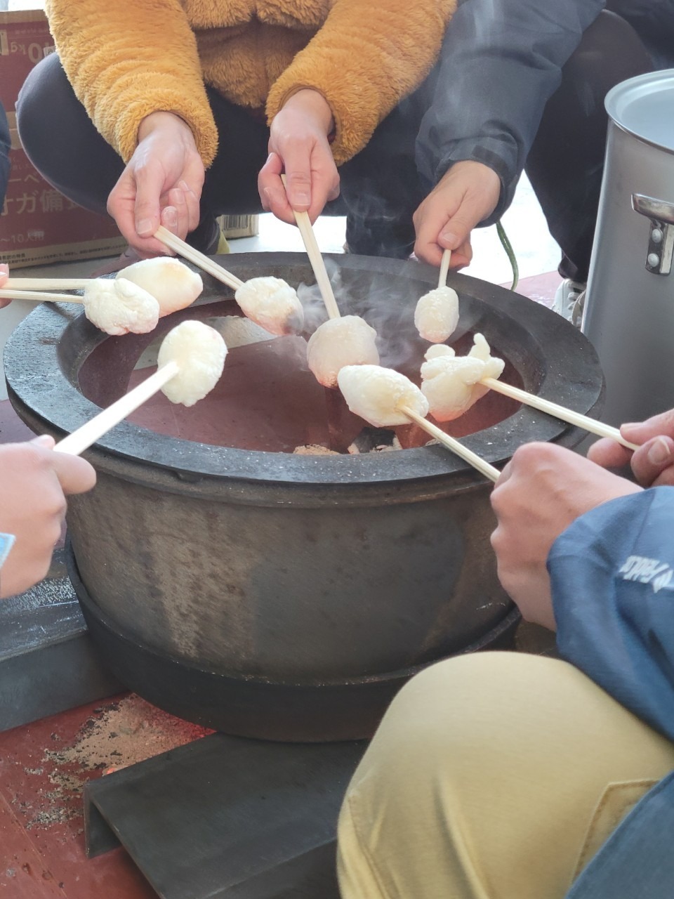 つきたての餅を串に刺して火鉢で焼いているところ