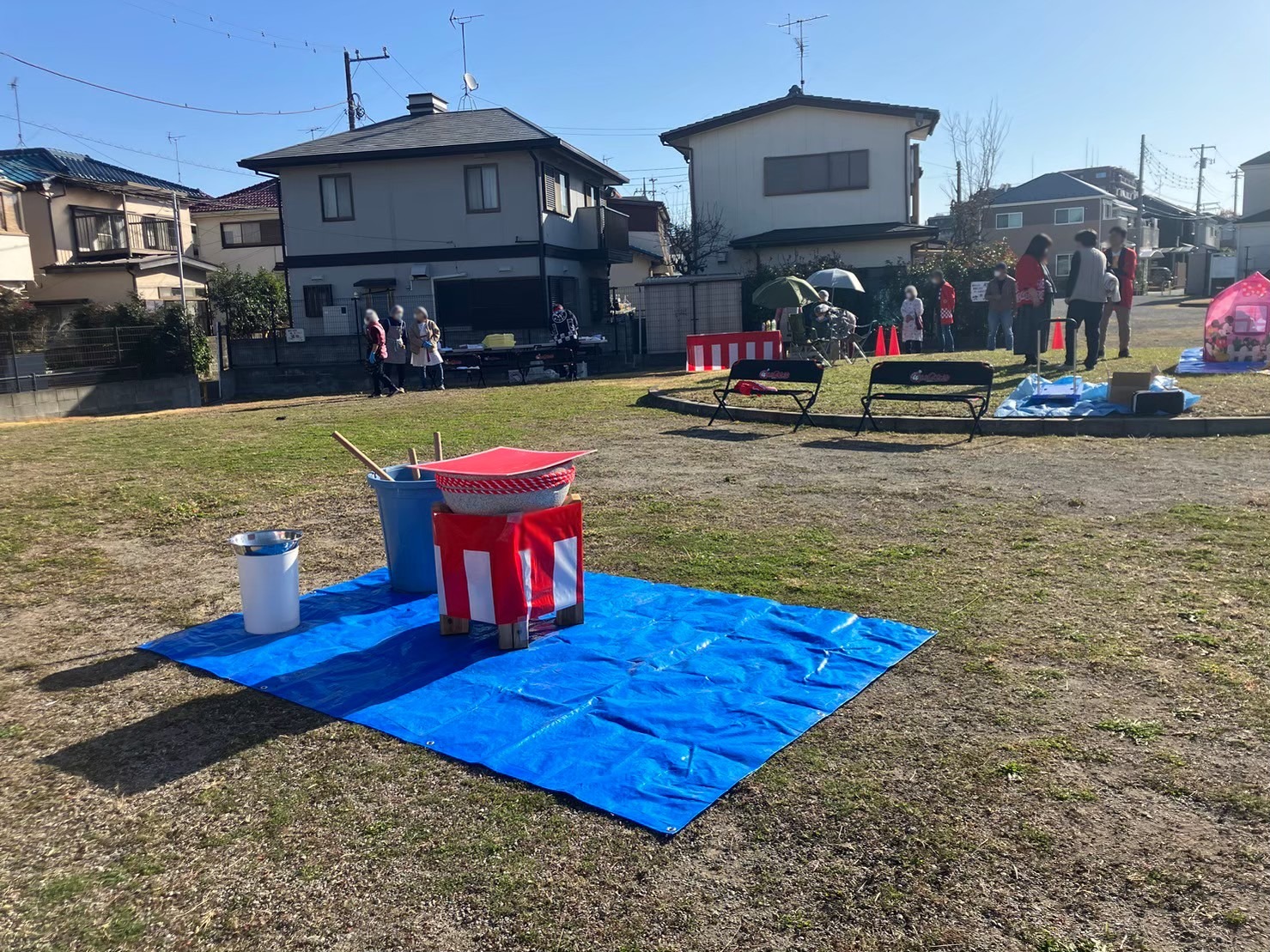 芝生の広場にブルーシートを敷いて臼と杵を設置した餅つき会場